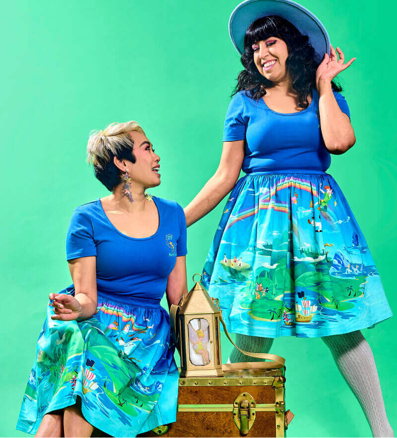 Green colored background with 2 models wearing Stitch Shoppe Peter Pan apparel. Click to shop apparel!