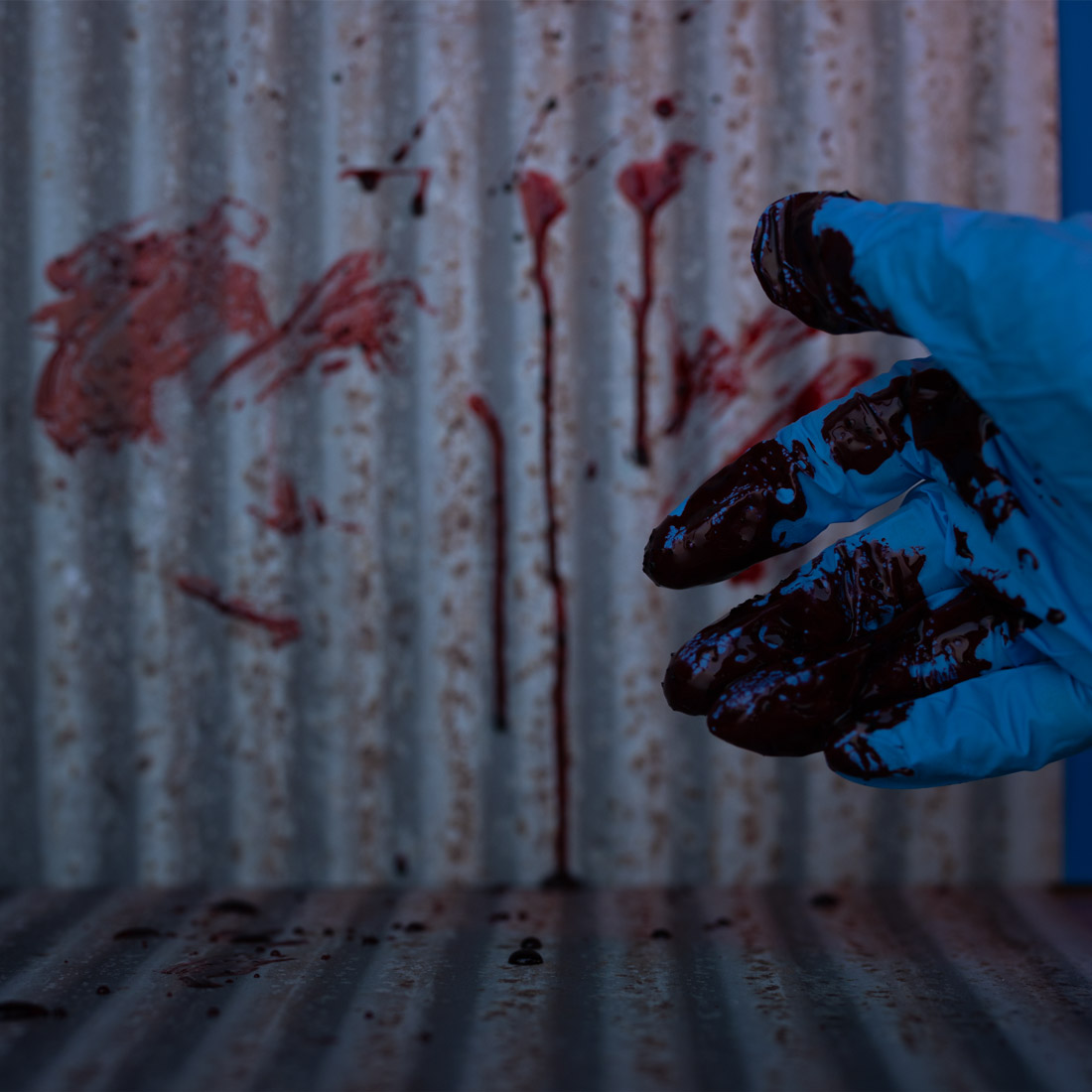 "Bloody" scene of corrugated sheet metal with a "bloody" glove in the foreground
