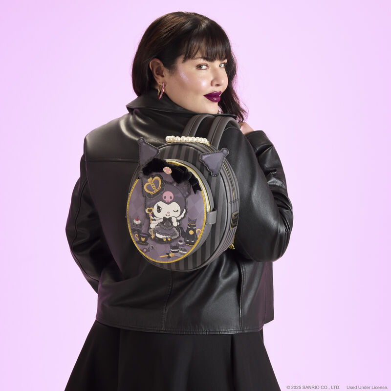 Woman facing away from camera wearing a black leather jacket. She wears the Loungefly Kuromi 20th anniversary cameo mini backpack over a shoulder. She stands against a purple-pink background. 